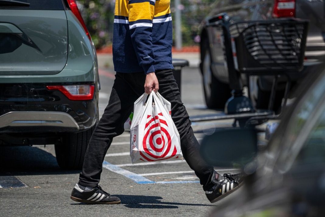 Target lowers its profit outlook as shoppers spend less.